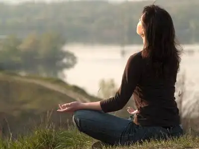 打坐的女商人年轻女子在瑜伽体式-鸽子姿势对窗口在健身工作室培训